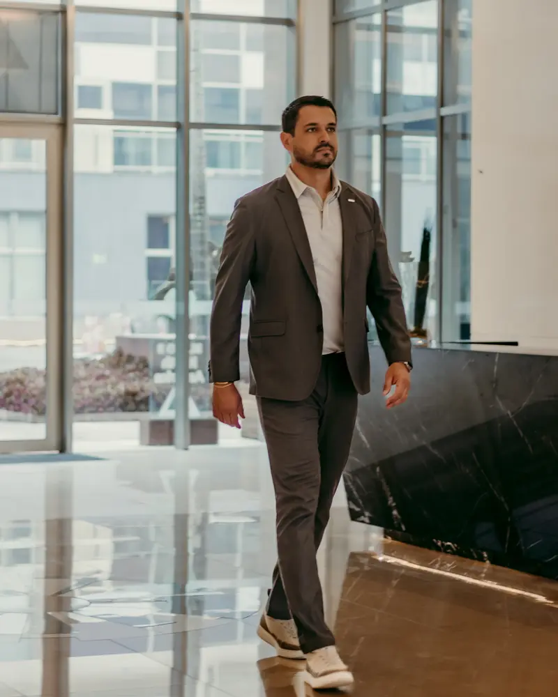 João Marot caminhando no saguão de um prédio comercial