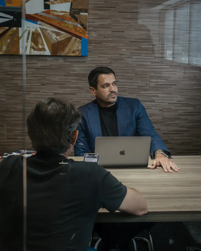 João Marot em reunião com cliente, com notebook aberto na mesa